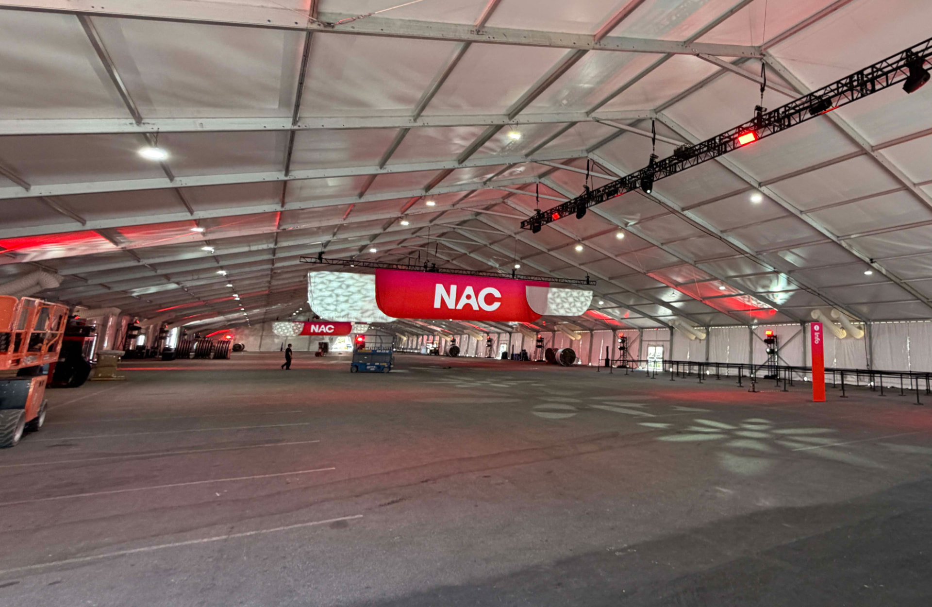 Large printed banners suspended from truss inside an event tent